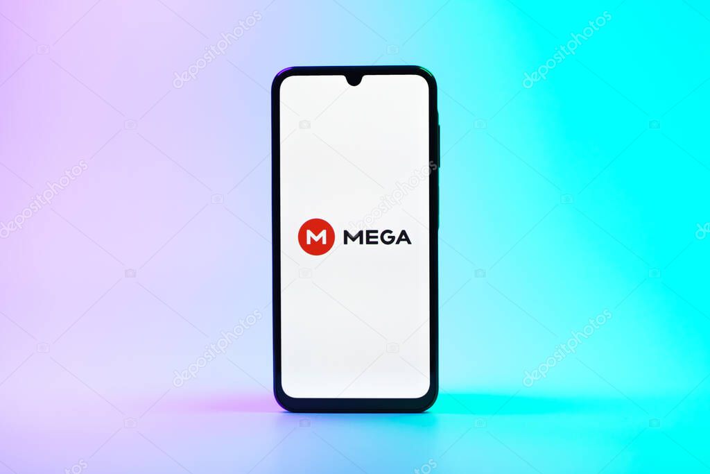 Prague, Czechia - 08 10 2025: A mobile phone standing on a uniform background displays the Mega logo. Mega is a platform for cloud storage with encrypted file sharing.