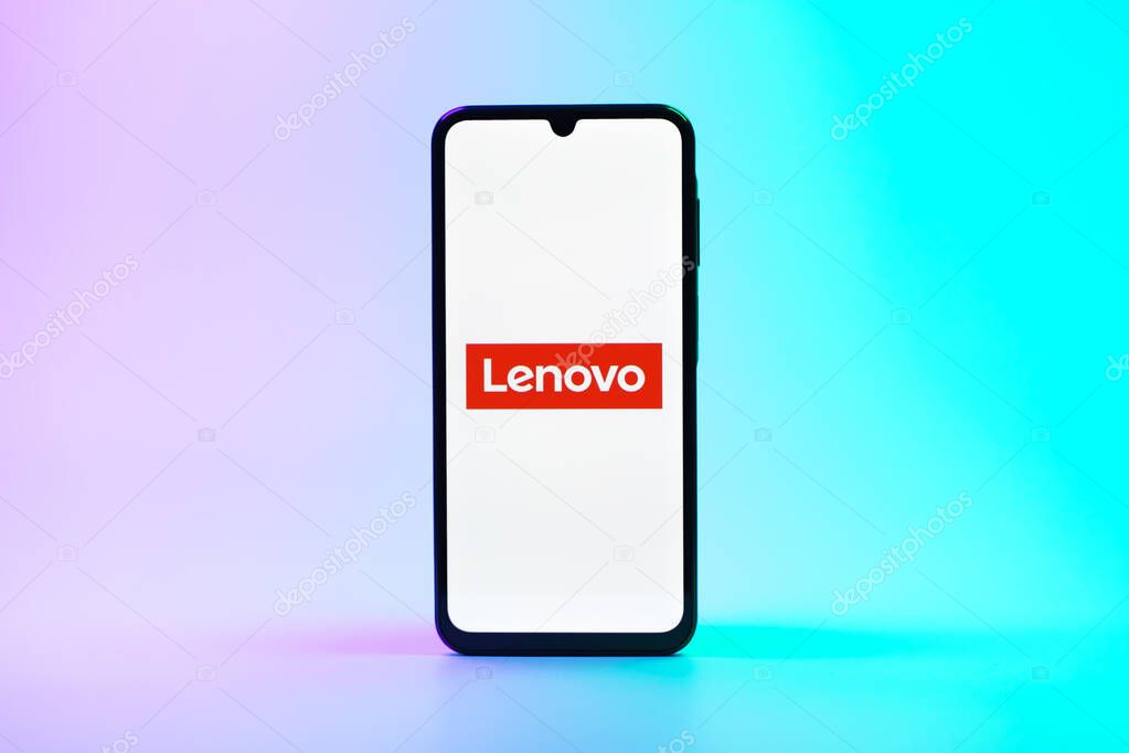 Prague, Czechia - 08 10 2025: A mobile phone standing on a uniform background displays the Lenovo logo. Lenovo is a technology company producing computers and electronics.
