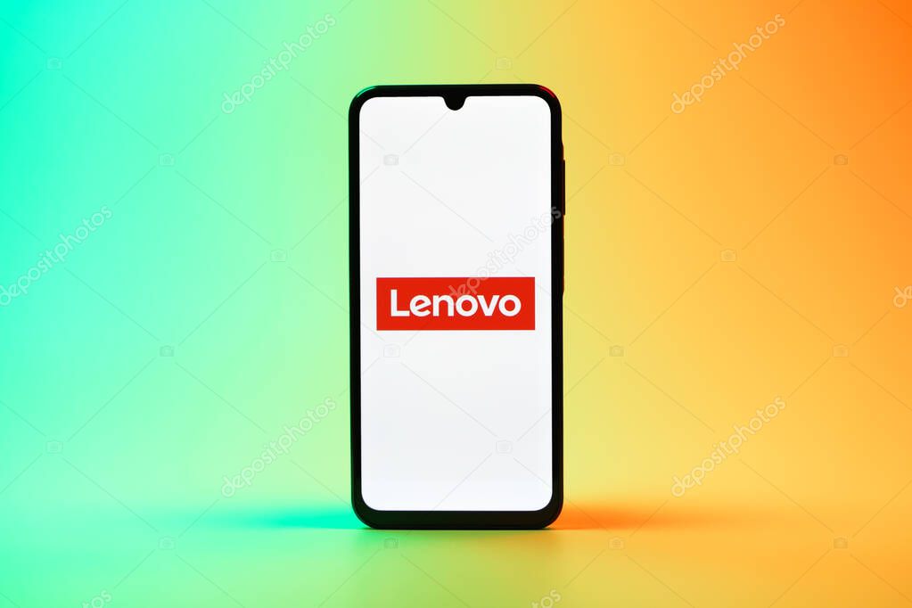 Prague, Czechia - 08 10 2025: A mobile phone standing on a uniform background displays the Lenovo logo. Lenovo is a technology company producing computers and electronics.