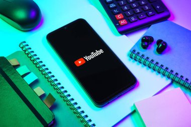 Prag, Çek Cumhuriyeti - 08 18 2025: Merkezde Youtube logosu sergilenen bir cep telefonu ile ofis malzemeleri düzenlemesi. Youtube dünya çapında videoları izlemek ve paylaşmak için bir platform.