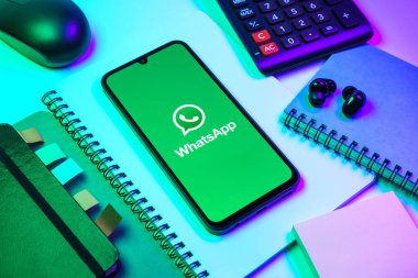 Prag, Çek Cumhuriyeti - 08 18 2025: Ofis malzemelerinin merkezde WhatsApp logosunu gösteren bir cep telefonu ile düzenlenmesi. WhatsApp mesaj, çağrı ve medya göndermek için bir uygulamadır.