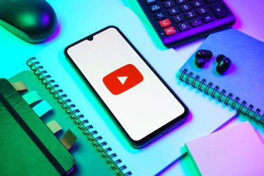 Prag, Çek Cumhuriyeti - 08 18 2025: Merkezde Youtube logosu sergilenen bir cep telefonu ile ofis malzemeleri düzenlemesi. Youtube dünya çapında videoları izlemek ve paylaşmak için bir platform.