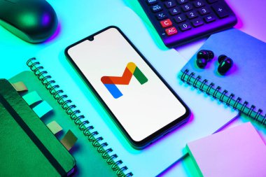 Prag, Çek Cumhuriyeti - 08 18 2025: Merkezde Google Gmail logosunu gösteren bir cep telefonu ile ofis malzemeleri düzenlemesi. Google Gmail, mesaj göndermek ve almak için kullanılan bir e-posta servisidir..