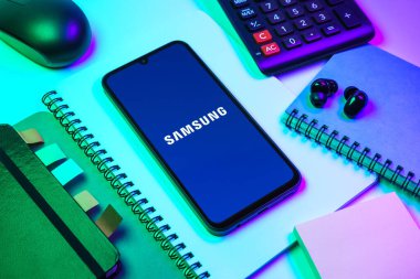 Prag, Çek Cumhuriyeti - 08 18 2025: Merkezde Samsung logosu sergilenen bir cep telefonu ile ofis malzemeleri düzenlemesi. Samsung elektronik ve cihaz üreten bir teknoloji şirketi..