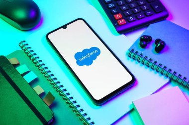 Prag, Çek Cumhuriyeti - 08 18 2025: Merkezde Satış Gücü logosunu gösteren bir cep telefonu ile ofis malzemeleri düzenlemesi. Satış gücü müşteri ilişkileri yönetimi ve bulut hizmetleri için bir platformdur..
