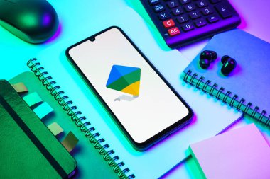 Prag, Çek Cumhuriyeti - 08 18 2025: Merkezde Google Family Link logosunu gösteren bir cep telefonu ile ofis malzemeleri düzenlemesi. Google Family Link ebeveyn denetimi ve çocuk hesabı yönetimi için bir platformdur.