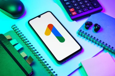 Prag, Çek Cumhuriyeti - 08 18 2025: Merkezinde Google One logosu bulunan bir cep telefonu ile ofis malzemeleri düzenlemesi. Google 1 bulut depolama ve abonelik hizmetleri için bir platformdur.