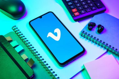 Prag, Çek Cumhuriyeti - 08 18 2025: Merkezde Vimeo logosunu gösteren bir cep telefonu ile ofis malzemeleri düzenlemesi. Vimeo, yüksek kaliteli video sunucu ve paylaşımı için bir platformdur.