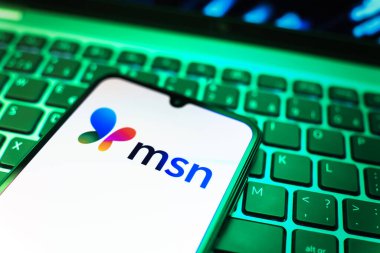 Prag, Çek Cumhuriyeti - 08 19 2025: MSN logosunu gösteren klavyenin üzerinde duran cep telefonunun yakından görüntüsü. MSN haber, e-posta ve çevrimiçi hizmetler için bir platformdur.