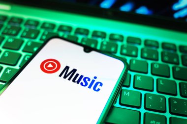 Prag, Çek Cumhuriyeti - 08 19 2025: Bir klavyenin üzerinde duran ve Youtube Müzik logosunu gösteren cep telefonunun yakından görüntüsü. Youtube Music müzik için bir platformdur..
