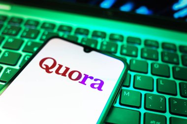 Prag, Çek Cumhuriyeti - 08 19 2025: Klavyede duran ve Quora logosunu gösteren cep telefonunun yakından görüntüsü. Quora soru sormak ve bilgi paylaşmak için bir platformdur..