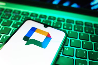 Prag, Çek Cumhuriyeti - 08 19 2025: Google Chat logosunu gösteren klavyenin üzerinde duran cep telefonunun yakından görüntüsü. Google Chat mesajlaşma ve takım işbirliği için bir platformdur.