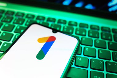 Prag, Çek Cumhuriyeti - 08 19 2025: Bir klavyenin üzerinde duran ve Google One logosunu gösteren cep telefonunun yakından görüntüsü. Google 1 bulut depolama ve abonelik hizmetleri için bir platformdur.
