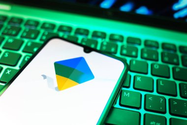 Prag, Çek Cumhuriyeti - 08 19 2025: Google Family Link logosunu gösteren klavyenin üzerinde duran cep telefonunun yakından görüntüsü. Google Family Link ebeveyn denetimi ve çocuk hesabı yönetimi için bir platformdur.