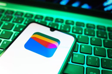 Prag, Çek Cumhuriyeti - 08 19 2025: Google Cüzdan logosunu gösteren klavyenin üzerinde duran cep telefonunun yakından görüntüsü. Google Cüzdanı dijital ödeme yöntemlerini depolamak ve kullanmak için bir platformdur.