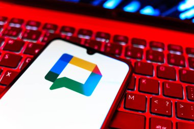 Prag, Çek Cumhuriyeti - 08 19 2025: Google Chat logosunu gösteren klavyenin üzerinde duran cep telefonunun yakından görüntüsü. Google Chat mesajlaşma ve takım işbirliği için bir platformdur.