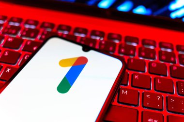 Prag, Çek Cumhuriyeti - 08 19 2025: Bir klavyenin üzerinde duran ve Google One logosunu gösteren cep telefonunun yakından görüntüsü. Google 1 bulut depolama ve abonelik hizmetleri için bir platformdur.