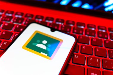 Prag, Çek Cumhuriyeti - 08 19 2025: Google Sınıfı logosunu gösteren klavyenin üzerinde duran cep telefonunun yakından görüntüsü. Google Sınıfı, sınıfları ve eğitim içeriğini yönetmek için bir platformdur.