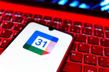Prag, Çek Cumhuriyeti - 08 19 2025: Google Takvim logosunu gösteren klavyenin üzerinde duran cep telefonunun yakından görüntüsü. Google Takvimi olayları zamanlamak ve yönetmek için bir platformdur.