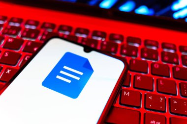 Prag, Çek Cumhuriyeti - 08 19 2025: Google Docs logosunu gösteren klavyenin üzerinde duran cep telefonunun yakından görüntüsü. Google Docs metin belgeleri oluşturmak ve düzenlemek için bir platformdur.