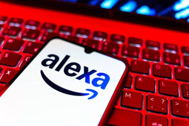 Prag, Çek Cumhuriyeti - 08 19 2025: Klavyenin üzerinde Alexa logosunu gösteren cep telefonunun yakın çekim görüntüsü. Alexa akıllı aygıtlar ve servisler için ses asistanıdır.