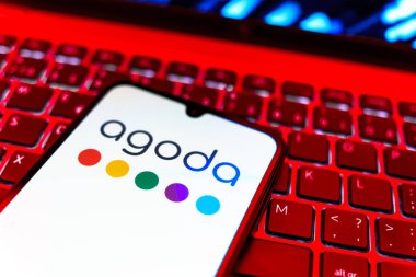 Prag, Çek Cumhuriyeti - 08 19 2025: Cep telefonunun klavyede duran ve Agoda logosunu gösteren yakın plan görüntüsü. Agoda, otelleri ve seyahat yerlerini ayırtmak için bir platform..