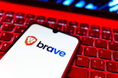 Prag, Çek Cumhuriyeti - 08 19 2025: Cesur logoyu gösteren klavyenin üzerinde duran cep telefonunun yakından görüntüsü. Brave, gizlilik ve hız odaklı bir web tarayıcısıdır.