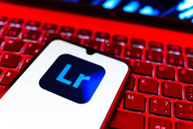 Prag, Çek Cumhuriyeti - 08 19 2025: Klavyede duran ve Lightroom logosunu gösteren cep telefonunun yakından görüntüsü. Lightroom fotoğraf düzenleme ve yönetim için bir yazılımdır..