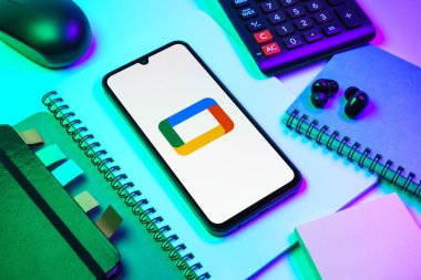 Prag, Çek Cumhuriyeti - 08 18 2025: Merkezde Google TV logosunu gösteren bir cep telefonu ile ofis malzemeleri düzenlemesi. Google TV film, program ve uygulamalar için bir platformdur..