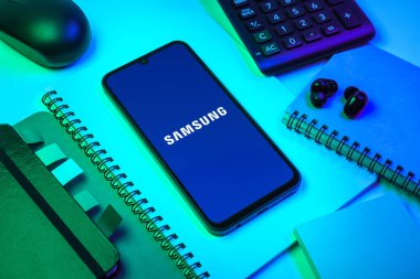Prag, Çek Cumhuriyeti - 08 18 2025: Merkezde Samsung logosu sergilenen bir cep telefonu ile ofis malzemeleri düzenlemesi. Samsung elektronik ve cihaz üreten bir teknoloji şirketi..