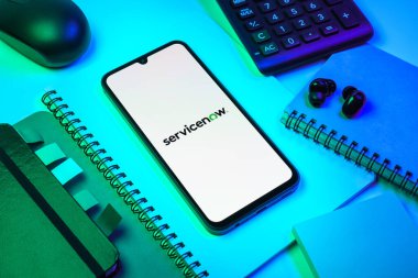 Prag, Çek Cumhuriyeti - 08 18 2025: Merkezde ServiceNow logosu sergilenen bir cep telefonu ile ofis malzemeleri düzenlemesi. ServiceNow iş akışı otomasyonu ve bilişim hizmeti yönetimi için bir platformdur.