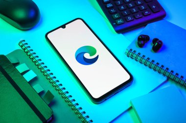 Prag, Çek Cumhuriyeti - 08 18 2025: Merkezde Edge logosunu gösteren bir cep telefonu ile ofis malzemeleri düzenlemesi. Edge, Microsoft tarafından Windows aygıtları için geliştirilen bir web tarayıcısıdır..