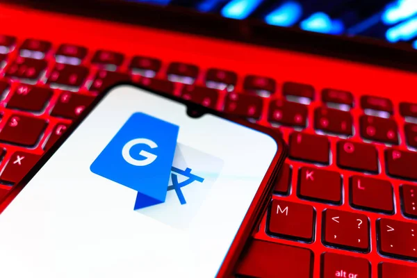 Prag, Çek Cumhuriyeti - 08 19 2025: Google Translate logosunu gösteren klavyenin üzerinde duran cep telefonunun yakından görüntüsü. Google Çevirisi metni ve konuşmayı diller arası çevirmek için bir platformdur..