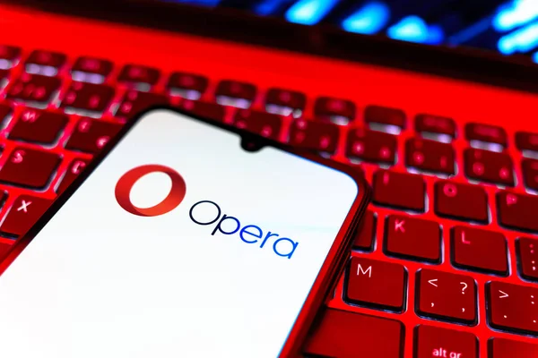 Prag, Çek Cumhuriyeti - 08 19 2025: Opera logosunu gösteren klavyenin üzerinde duran cep telefonunun yakından görüntüsü. Opera hızlı ve güvenli internet taraması için bir web tarayıcısıdır.