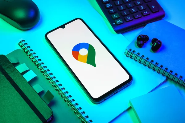 Prag, Çek Cumhuriyeti - 08 18 2025: Merkezde Google Maps logosunu gösteren bir cep telefonu ile ofis malzemeleri düzenlemesi. Google Maps haritalar, navigasyon ve konum hizmetleri için bir platformdur.