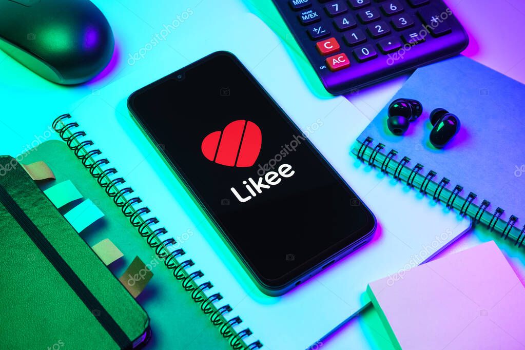 Prague, Czechia - 08 18 2025: An arrangement of office supplies with a mobile phone in the center displaying Likee logo. Likee is a platform for creating and sharing short videos.