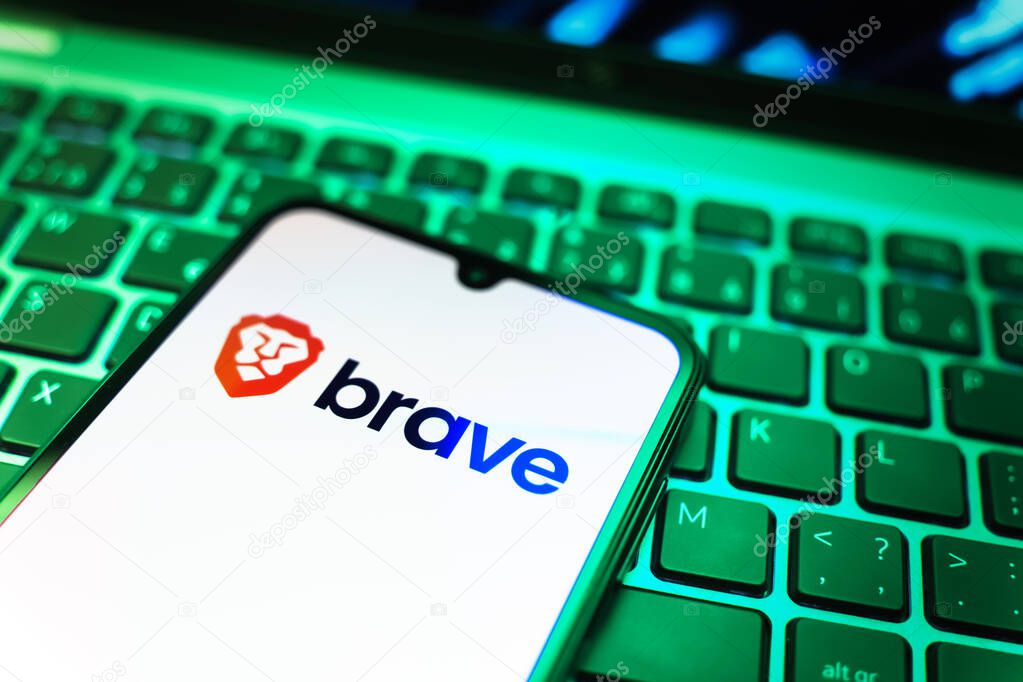 Prague, Czechia - 08 19 2025: A close-up view of a mobile phone lying on a keyboard, displaying Brave logo. Brave is a web browser focused on privacy and speed.