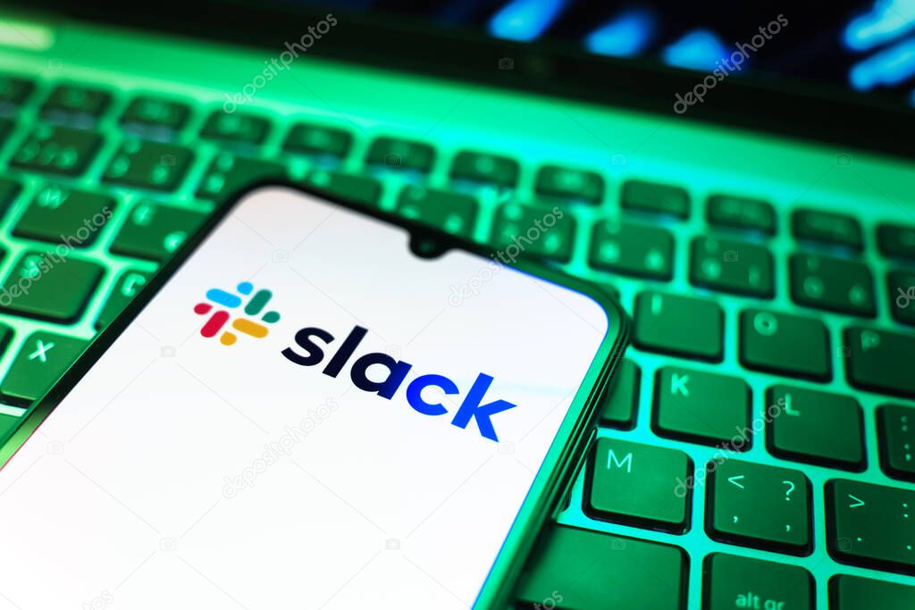Prague, Czechia - 08 19 2025: A close-up view of a mobile phone lying on a keyboard, displaying Slack logo. Slack is a platform for team messaging and workplace communication.