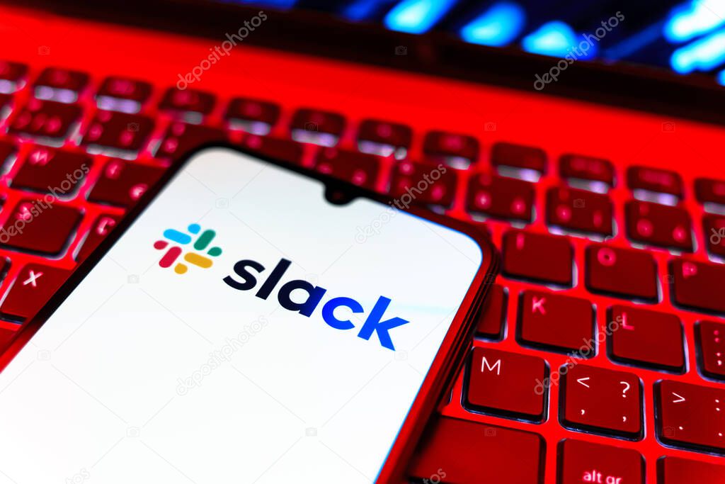 Prague, Czechia - 08 19 2025: A close-up view of a mobile phone lying on a keyboard, displaying Slack logo. Slack is a platform for team messaging and workplace communication.