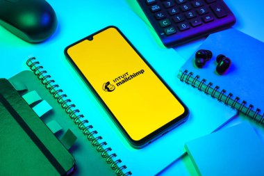 Prag, Çek Cumhuriyeti - 08 18 2025: Posta şempanzesinin logosunu gösteren bir cep telefonu ile ofis malzemeleri düzenlemesi. Posta şempanzesi e-posta pazarlama ve otomasyon için bir platformdur.