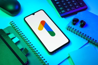 Prag, Çek Cumhuriyeti - 08 18 2025: Merkezinde Google One logosu bulunan bir cep telefonu ile ofis malzemeleri düzenlemesi. Google 1 bulut depolama ve abonelik hizmetleri için bir platformdur.