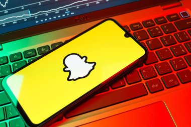Prag, Çek Cumhuriyeti - 08 18 2025: Klavyede bir cep telefonu Snapchat logosu sergiler. Snapchat fotoğraf, video ve geçici mesajlar göndermek için bir uygulamadır.