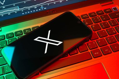 Prag, Çek Cumhuriyeti - 08 18 2025: Klavyede bir cep telefonu X logosu sergiler. X, kısa gönderileri ve güncellemeleri paylaşmak için bir platformdur.
