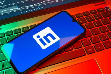Prag, Çek Cumhuriyeti - 08 18 2025: Klavyede bir cep telefonu LinkedIn logosunu gösterir. LinkedIn, insanları ve şirketleri birbirine bağlayan profesyonel bir ağ..