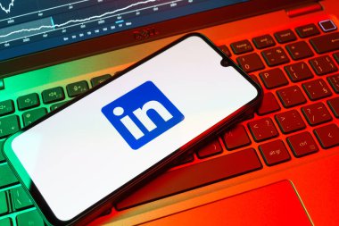 Prag, Çek Cumhuriyeti - 08 18 2025: Klavyede bir cep telefonu LinkedIn logosunu gösterir. LinkedIn, insanları ve şirketleri birbirine bağlayan profesyonel bir ağ..