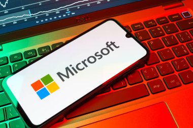 Prag, Çek Cumhuriyeti - 08 18 2025: Klavyede bir cep telefonu Microsoft logosu sergiler. Microsoft yazılım, donanım ve hizmet sunan bir teknoloji şirketidir..