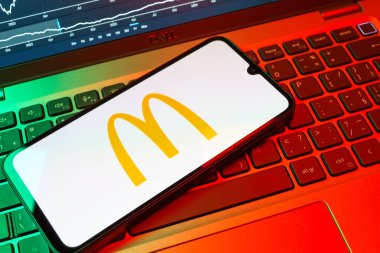 Prag, Çek Cumhuriyeti - 08 18 2025: Klavyede bir cep telefonu McDonalds logosu sergiler. McDonalds hamburger, patates kızartması ve daha fazlası sunan bir fast-food zinciri..