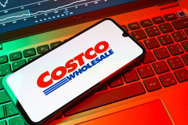Prag, Çek Cumhuriyeti - 08 18 2025: Klavyede bir cep telefonu Costco logosu sergiler. Costco toptan satış yapan bir perakendecidir. Üyelere toptan ürün satar..