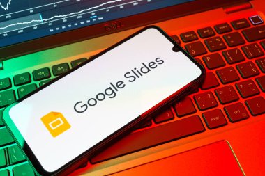 Prag, Çek Cumhuriyeti - 08 18 2025: Klavyede bir cep telefonu Google Slides logosunu görüntüler. Google Slides sunumlar ve slayt gösterileri oluşturmak için bir platformdur.