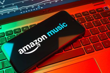 Prag, Çek Cumhuriyeti - 08 18 2025: Klavyede bir cep telefonu Amazon Müzik logosu sergiler. Amazon Müzik müzik müzik için bir platformdur..